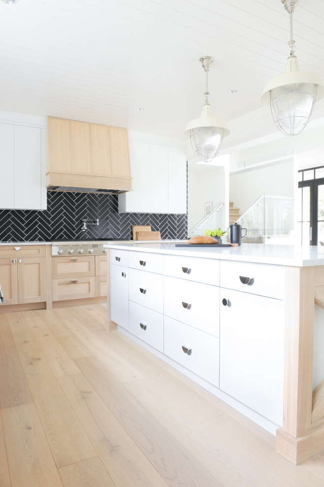 他の地域にある北欧スタイルのおしゃれなキッチン (黒いキッチンパネル、シルバーの調理設備、白いキッチンカウンター、塗装板張りの天井) の写真