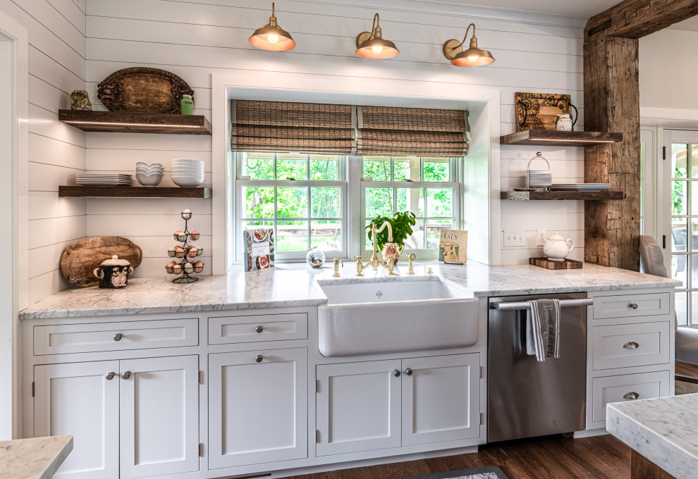 Eat-in kitchen - mid-sized country u-shaped light wood floor eat-in kitchen idea in Philadelphia with a farmhouse sink, shaker cabinets, white cabinets, quartz countertops, white backsplash, stainless steel appliances, an island and white countertops