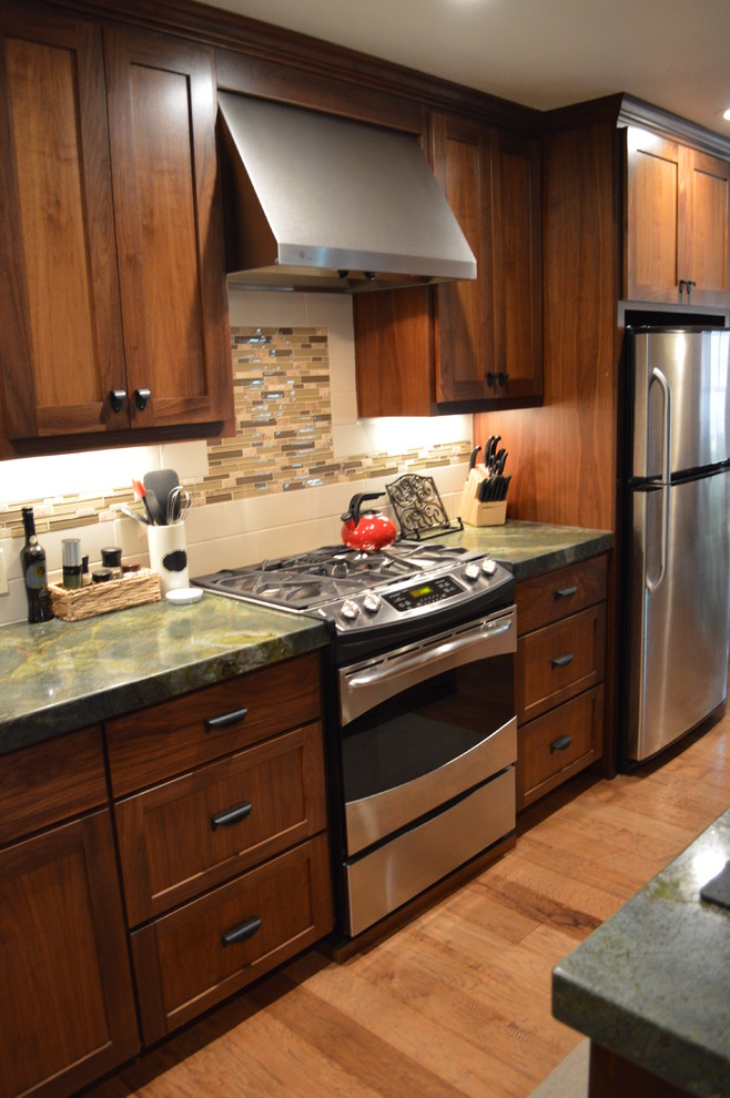 Bild på ett mellanstort amerikanskt kök, med skåp i shakerstil, skåp i mörkt trä, granitbänkskiva, en köksö, beige stänkskydd, stänkskydd i stickkakel, rostfria vitvaror, en rustik diskho, mellanmörkt trägolv och brunt golv