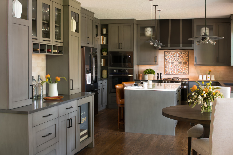 Expansive traditional u-shaped kitchen/diner in Minneapolis with a submerged sink, grey cabinets, engineered stone countertops, metro tiled splashback, black appliances, an island, shaker cabinets, dark hardwood flooring, brown floors and white worktops.