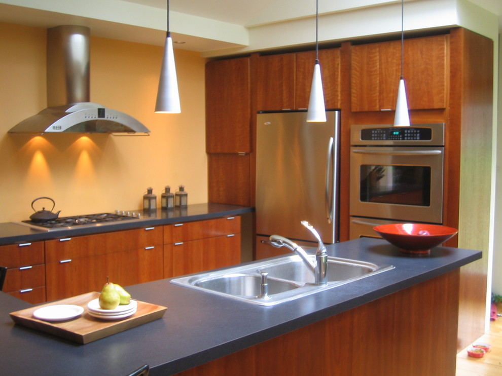 Foto di una cucina american style di medie dimensioni con lavello da incasso, ante lisce, ante in legno scuro, top in laminato, paraspruzzi giallo e elettrodomestici in acciaio inossidabile