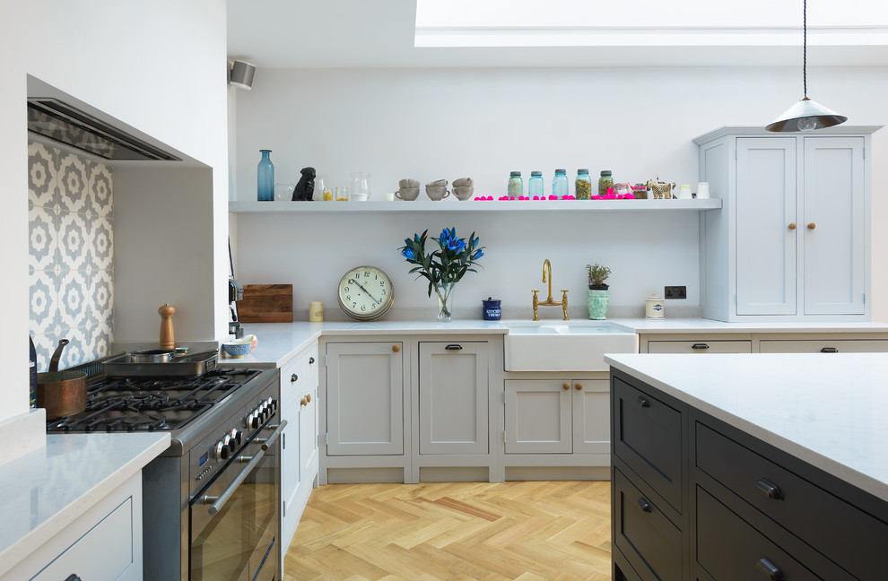 Photo of a medium sized country kitchen/diner in London with shaker cabinets, marble worktops, multi-coloured splashback, ceramic splashback, light hardwood flooring and an island.
