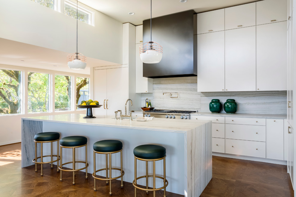 Eat-in kitchen - mid-sized contemporary l-shaped medium tone wood floor and brown floor eat-in kitchen idea in Portland with flat-panel cabinets, white cabinets, paneled appliances, an island, marble countertops, gray backsplash, marble backsplash and a farmhouse sink