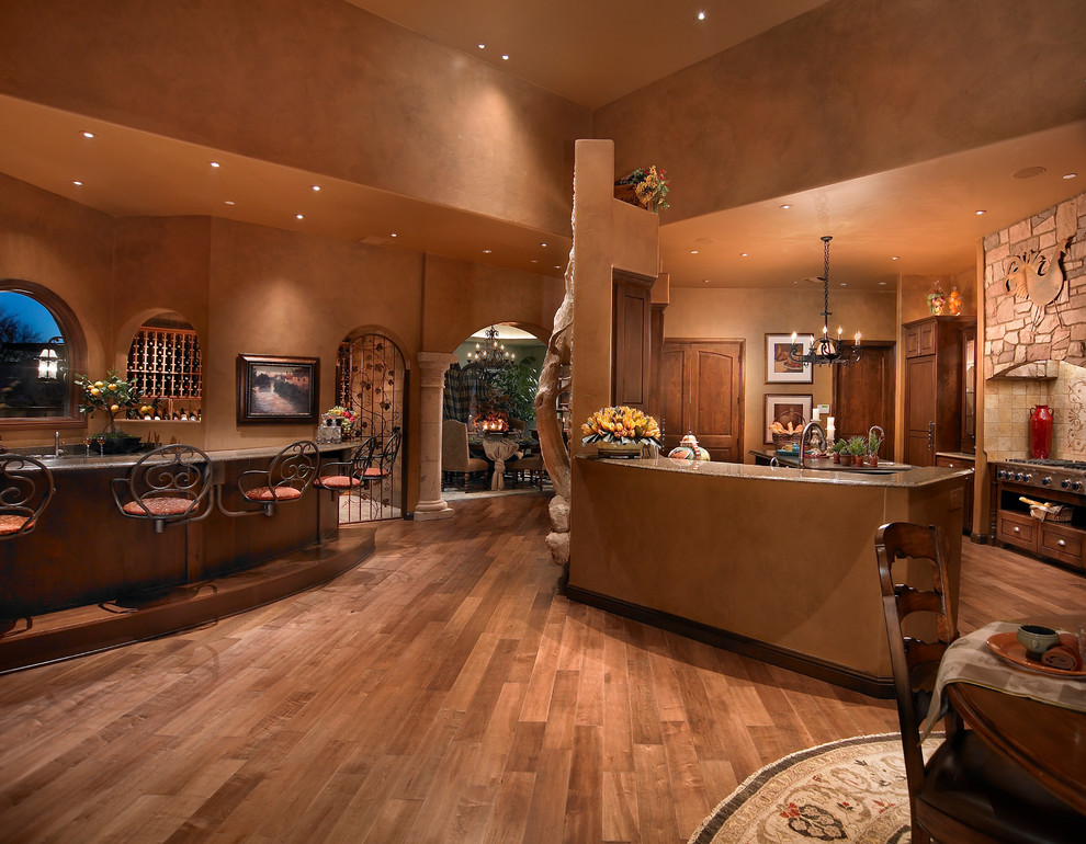 Offene Mediterrane Küche mit hellbraunen Holzschränken und braunem Holzboden in Phoenix
