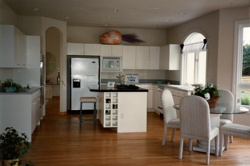 Example of a mid-sized trendy u-shaped eat-in kitchen design in Seattle with a double-bowl sink and flat-panel cabinets