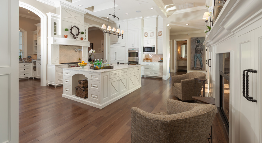 Inspiration for a huge timeless u-shaped medium tone wood floor and brown floor eat-in kitchen remodel in Portland with an undermount sink, raised-panel cabinets, white cabinets, marble countertops, white backsplash, glass tile backsplash, paneled appliances and two islands