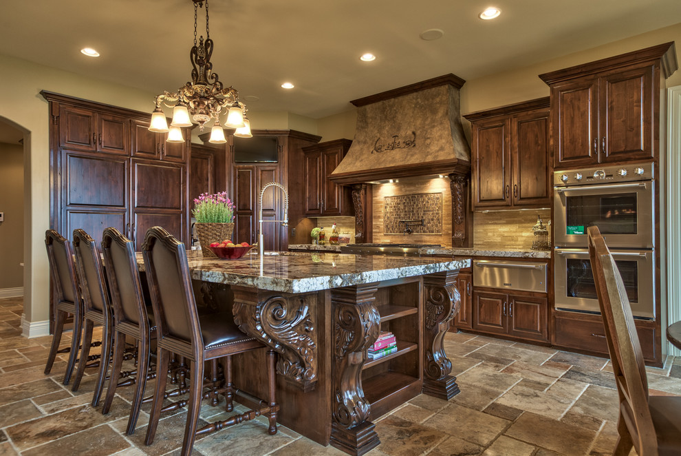 Inspiration for a large mediterranean l-shaped open concept kitchen remodel in Omaha with raised-panel cabinets, dark wood cabinets, stone tile backsplash, paneled appliances, granite countertops and beige backsplash