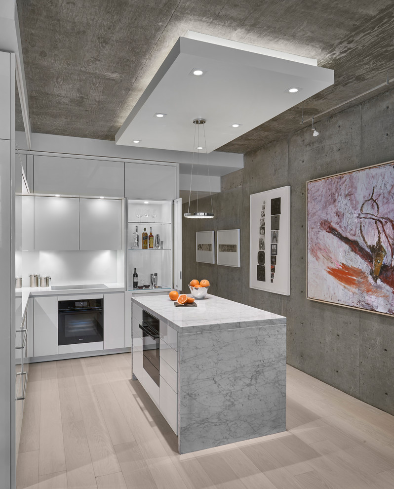 Foto di una piccola cucina contemporanea con ante bianche, paraspruzzi bianco, parquet chiaro, pavimento beige, ante lisce, elettrodomestici neri e top bianco