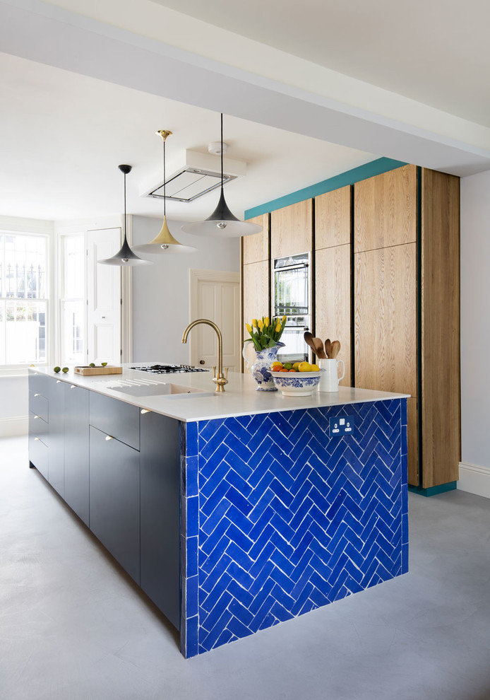 Zweizeilige Moderne Küche mit flächenbündigen Schrankfronten, hellbraunen Holzschränken, Betonboden, Kücheninsel, grauem Boden und weißer Arbeitsplatte in London