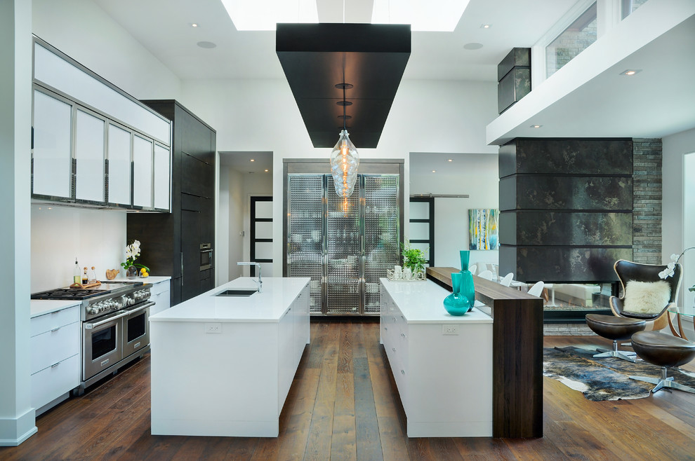 Open concept kitchen - huge modern l-shaped medium tone wood floor open concept kitchen idea in Toronto with an undermount sink, flat-panel cabinets, white cabinets, quartz countertops, white backsplash, paneled appliances and two islands