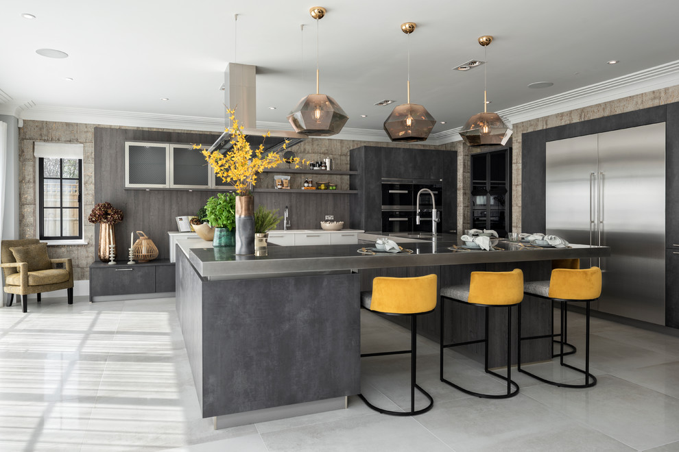 Open concept kitchen - large contemporary u-shaped open concept kitchen idea in Buckinghamshire with flat-panel cabinets, gray cabinets and an island