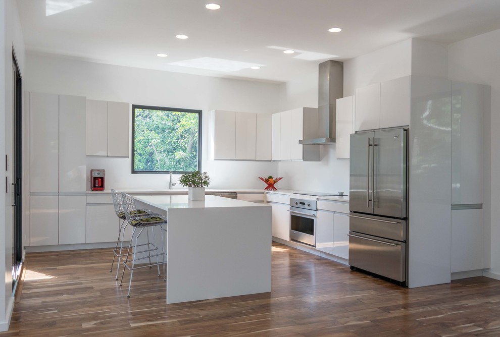 Inspiration for a mid-sized contemporary l-shaped dark wood floor and brown floor eat-in kitchen remodel in Miami with an integrated sink, flat-panel cabinets, white cabinets, quartz countertops, stainless steel appliances and an island