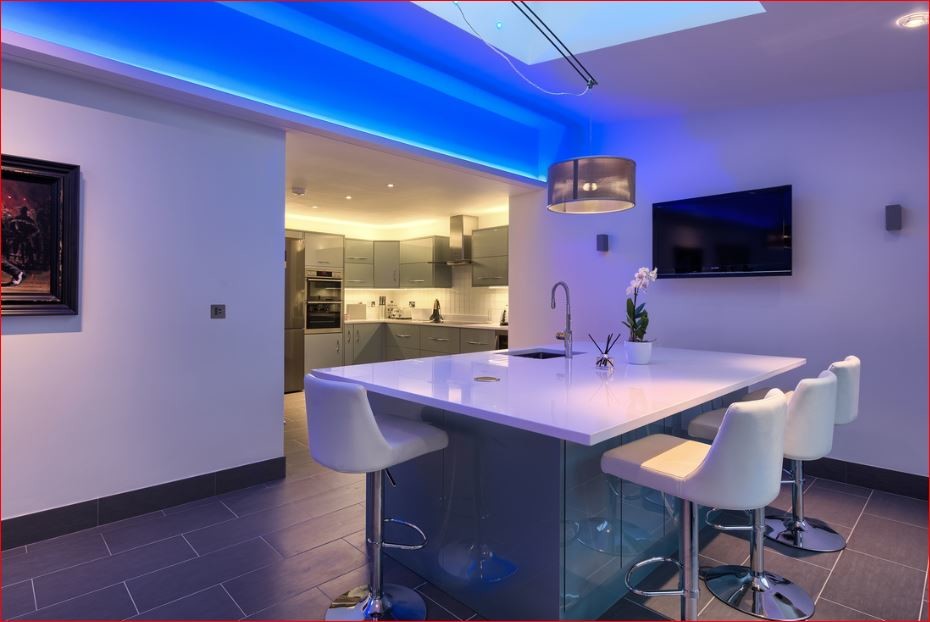 Exempel på ett mellanstort modernt kök, med en nedsänkt diskho, släta luckor, blå skåp, vitt stänkskydd, stänkskydd i stickkakel, rostfria vitvaror, klinkergolv i keramik och en köksö