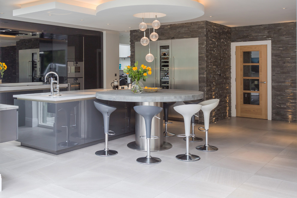 This is an example of a large contemporary kitchen/diner in Manchester with a built-in sink, grey cabinets, granite worktops, metallic splashback, glass sheet splashback, stainless steel appliances, porcelain flooring, multiple islands, grey floors and white worktops.
