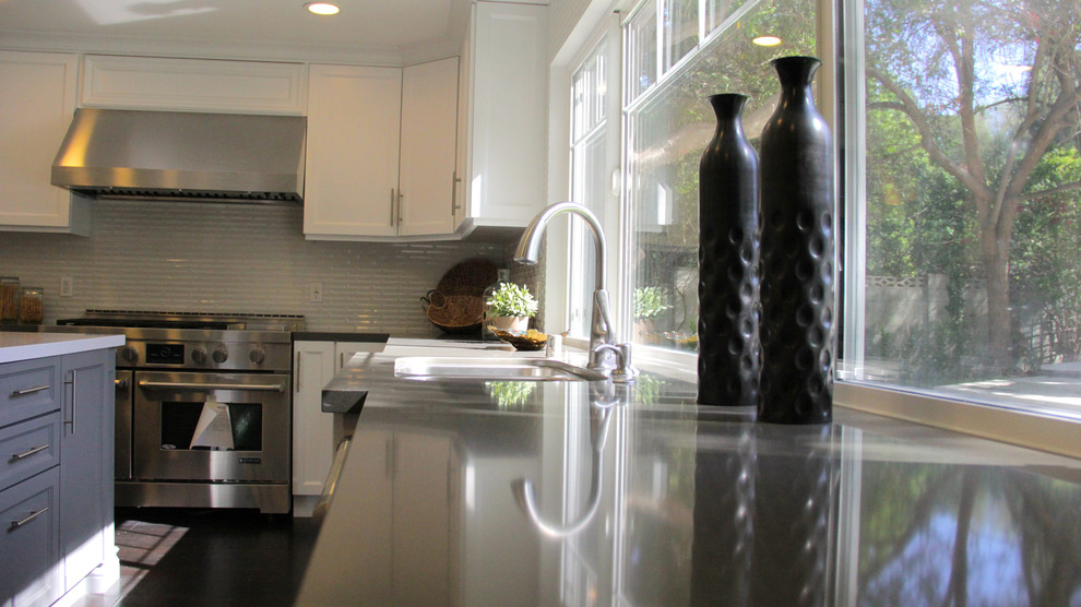 Bild på ett mellanstort vintage grå grått kök, med en undermonterad diskho, luckor med upphöjd panel, grå skåp, rostfria vitvaror, mörkt trägolv, en köksö, bänkskiva i betong, vitt stänkskydd, stänkskydd i stickkakel och svart golv