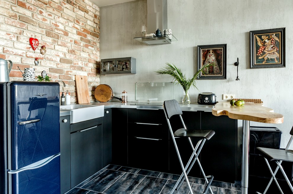 Свежая идея для дизайна: угловая кухня в стиле фьюжн с плоскими фасадами, черными фасадами, фартуком из кирпича и синим полом - отличное фото интерьера