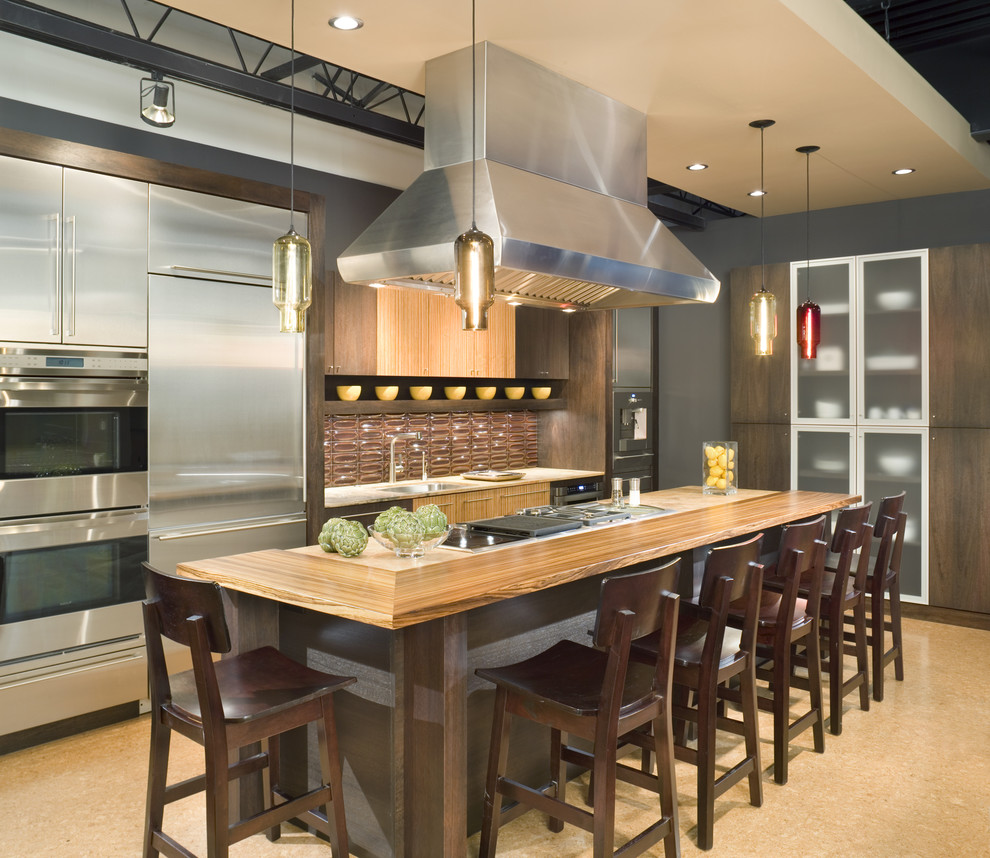 Eat-in kitchen - mid-sized contemporary galley cork floor eat-in kitchen idea in Kansas City with a single-bowl sink, flat-panel cabinets, dark wood cabinets, limestone countertops, red backsplash, ceramic backsplash, stainless steel appliances and an island
