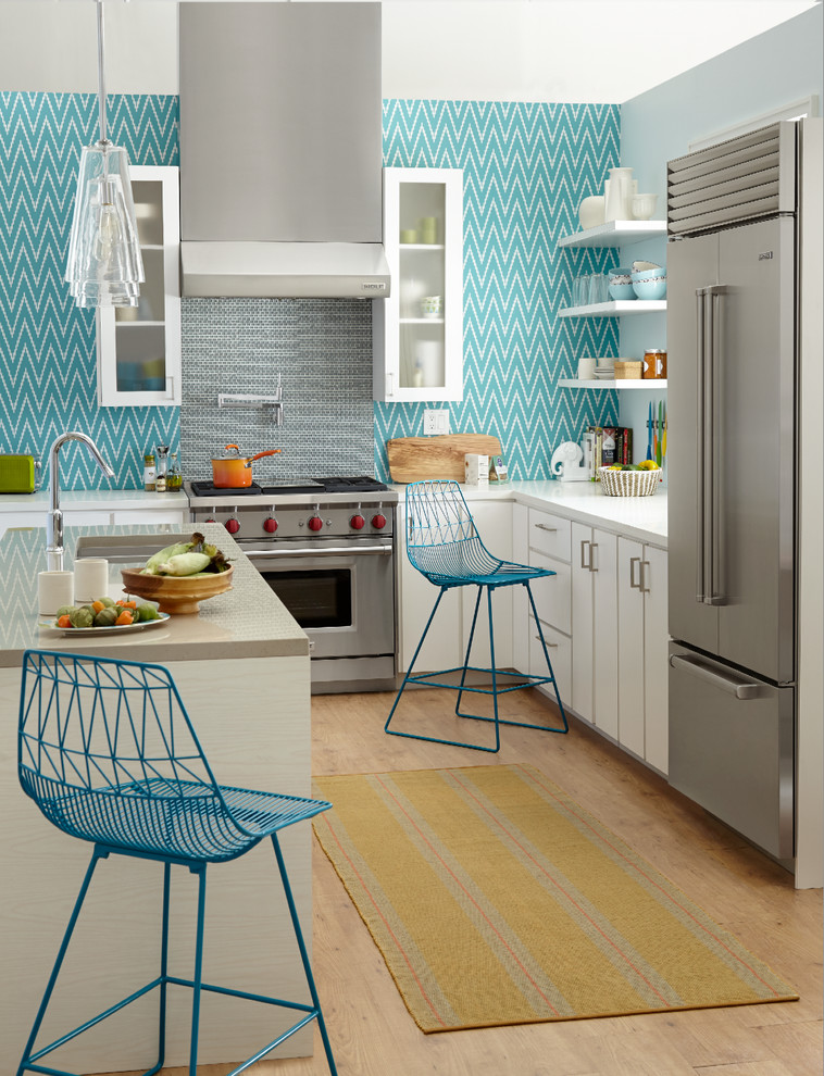Moderne Küche in L-Form mit flächenbündigen Schrankfronten, weißen Schränken, Küchenrückwand in Blau, Küchengeräten aus Edelstahl, braunem Holzboden, Kücheninsel und Tapete in Minneapolis