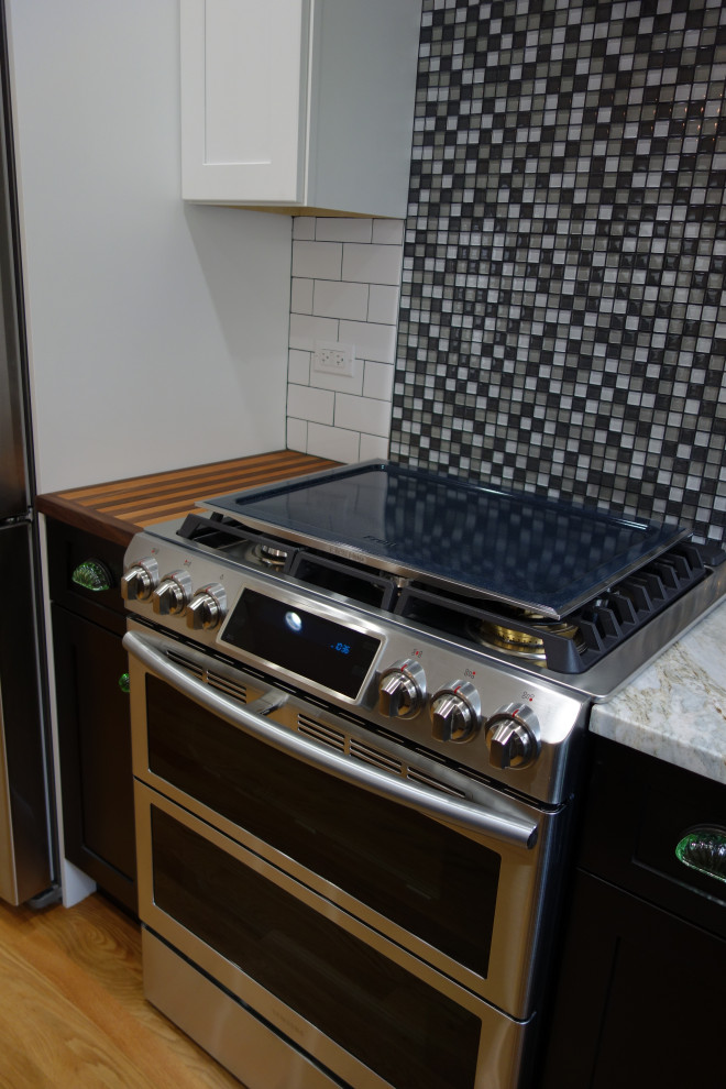 Foto på ett mellanstort funkis grå kök, med en enkel diskho, skåp i shakerstil, vita skåp, bänkskiva i kvartsit, vitt stänkskydd, stänkskydd i tunnelbanekakel, rostfria vitvaror, mellanmörkt trägolv, en halv köksö och brunt golv