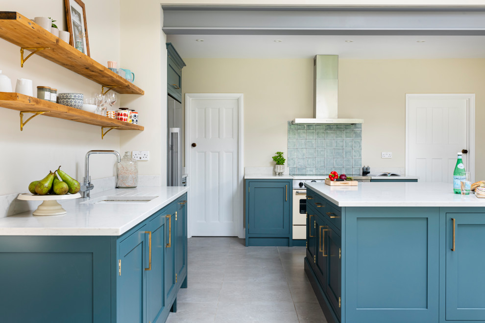 Mittelgroße Klassische Wohnküche in L-Form mit Schrankfronten im Shaker-Stil, blauen Schränken, Quarzit-Arbeitsplatte, Kücheninsel und weißer Arbeitsplatte in London