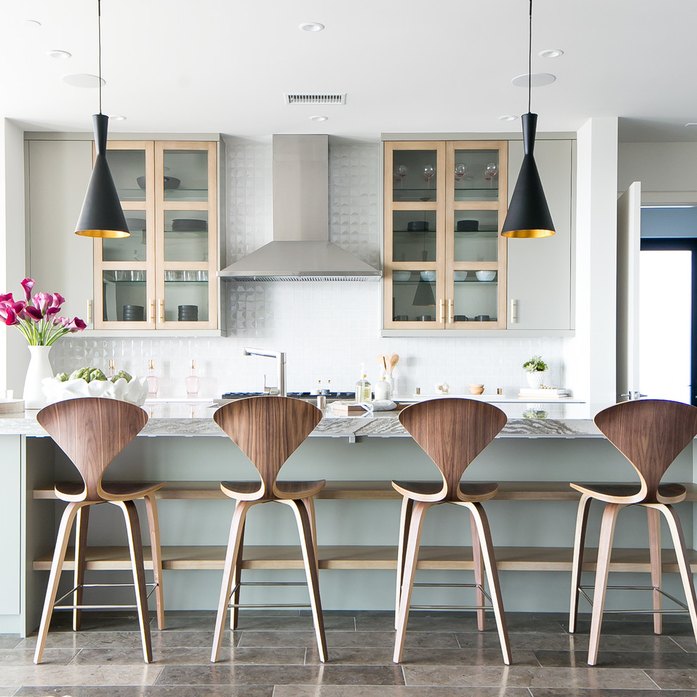 Idee per un cucina con isola centrale design di medie dimensioni con ante di vetro, paraspruzzi bianco e pavimento marrone