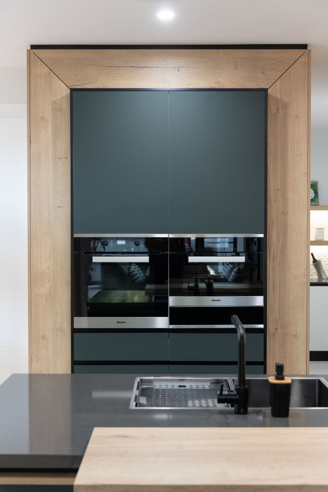 Große Moderne Küche in L-Form mit flächenbündigen Schrankfronten, Mineralwerkstoff-Arbeitsplatte, Kücheninsel und grünen Schränken in Gold Coast - Tweed