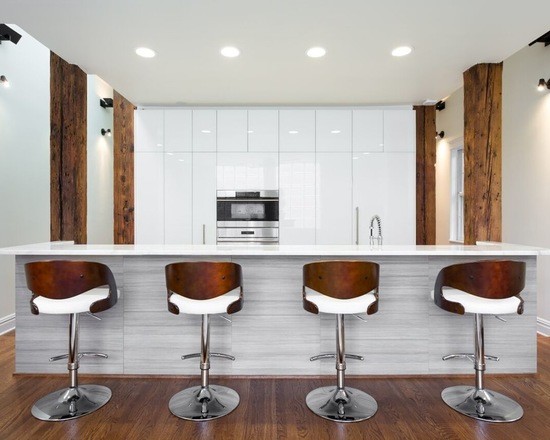 Idéer för stora funkis linjära kök och matrum, med en undermonterad diskho, släta luckor, vita skåp, marmorbänkskiva, integrerade vitvaror, mellanmörkt trägolv och en köksö