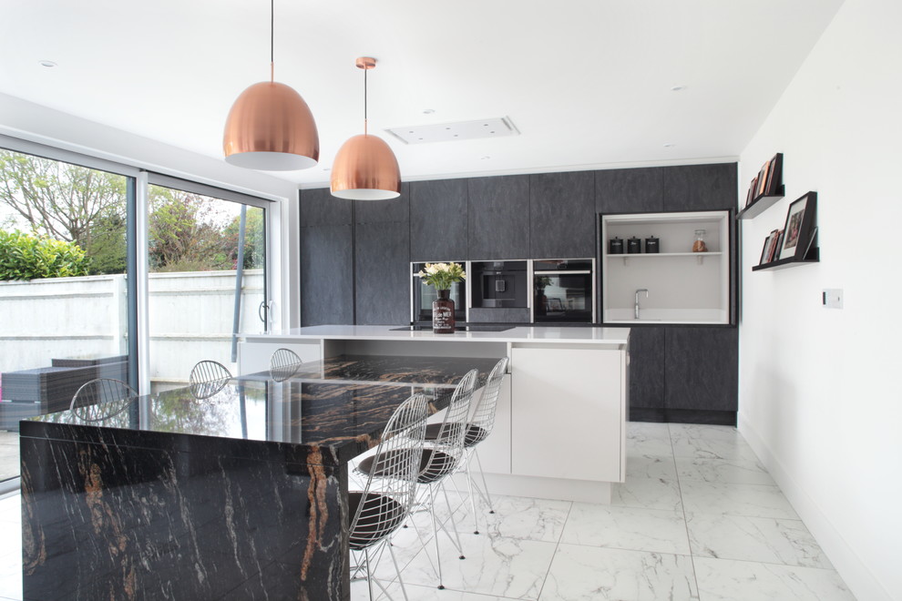 This is an example of a medium sized contemporary galley kitchen/diner in Buckinghamshire with a submerged sink, flat-panel cabinets, black cabinets, black appliances, an island, grey floors and white worktops.