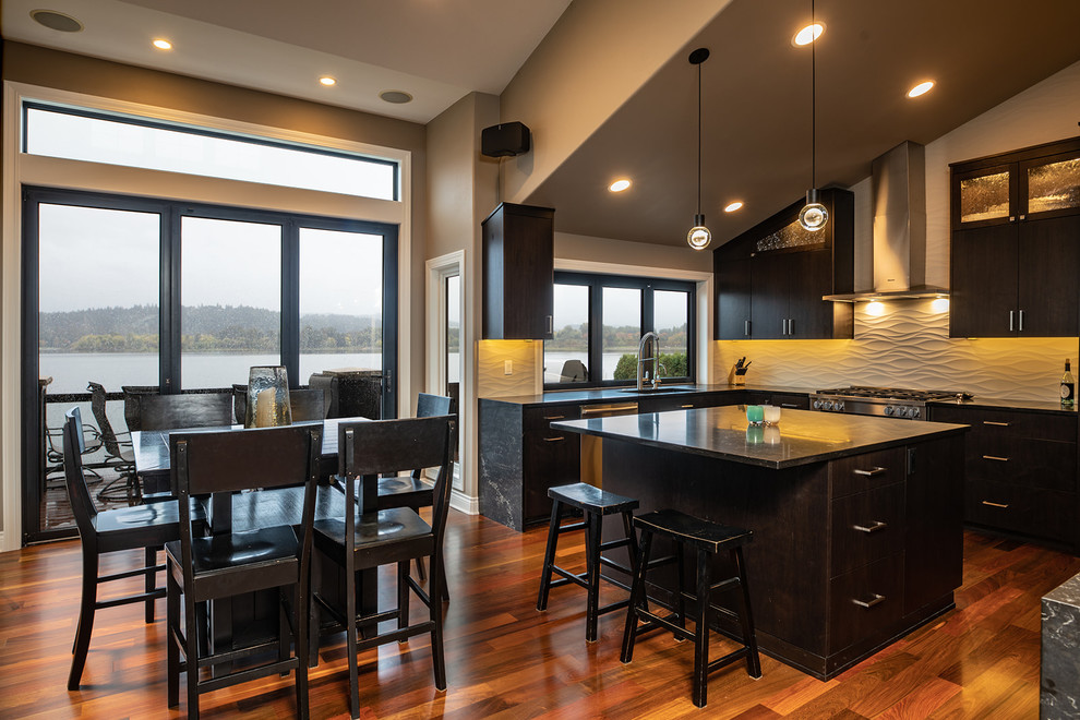 Inspiration for an expansive contemporary u-shaped open plan kitchen in Seattle with a submerged sink, flat-panel cabinets, dark wood cabinets, engineered stone countertops, beige splashback, porcelain splashback, stainless steel appliances, medium hardwood flooring, an island, brown floors and black worktops.