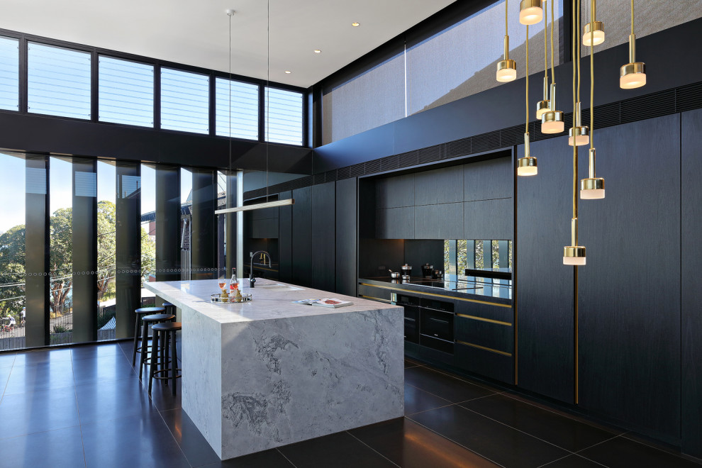 Idee per una grande cucina design con lavello a doppia vasca, ante lisce, ante nere, paraspruzzi a specchio, elettrodomestici da incasso, pavimento nero e top grigio