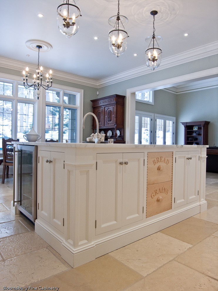 Example of a large farmhouse u-shaped limestone floor and beige floor open concept kitchen design in Toronto with a farmhouse sink, shaker cabinets, white cabinets, marble countertops, white backsplash, subway tile backsplash, stainless steel appliances and an island