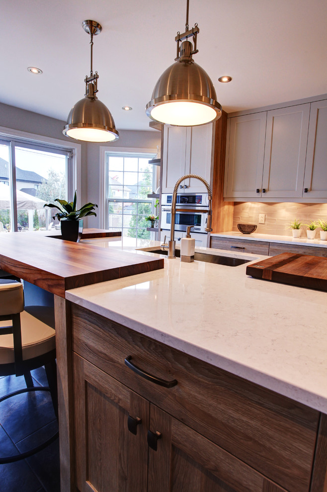 Kitchen - eclectic kitchen idea in Montreal with shaker cabinets, quartz countertops and stainless steel appliances