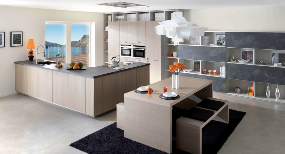 Immagine di una cucina minimalista di medie dimensioni con lavello a vasca singola, ante lisce, ante in legno chiaro, top in quarzite, elettrodomestici da incasso, pavimento in cemento e penisola