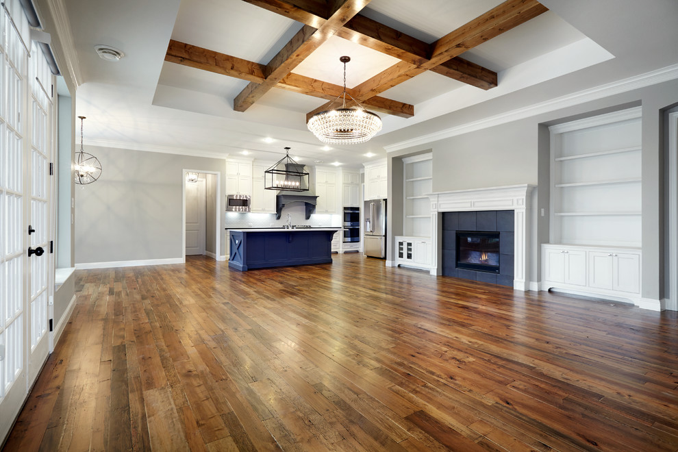 Kleine Moderne Wohnküche in L-Form mit Küchengeräten aus Edelstahl, braunem Holzboden, Kücheninsel, braunem Boden und weißen Schränken in Dallas