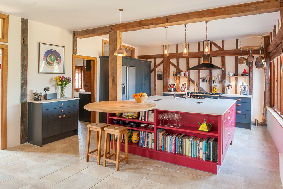 Bild på ett mellanstort lantligt kök, med röda skåp, rostfria vitvaror, beiget golv, luckor med infälld panel, travertin golv och en halv köksö