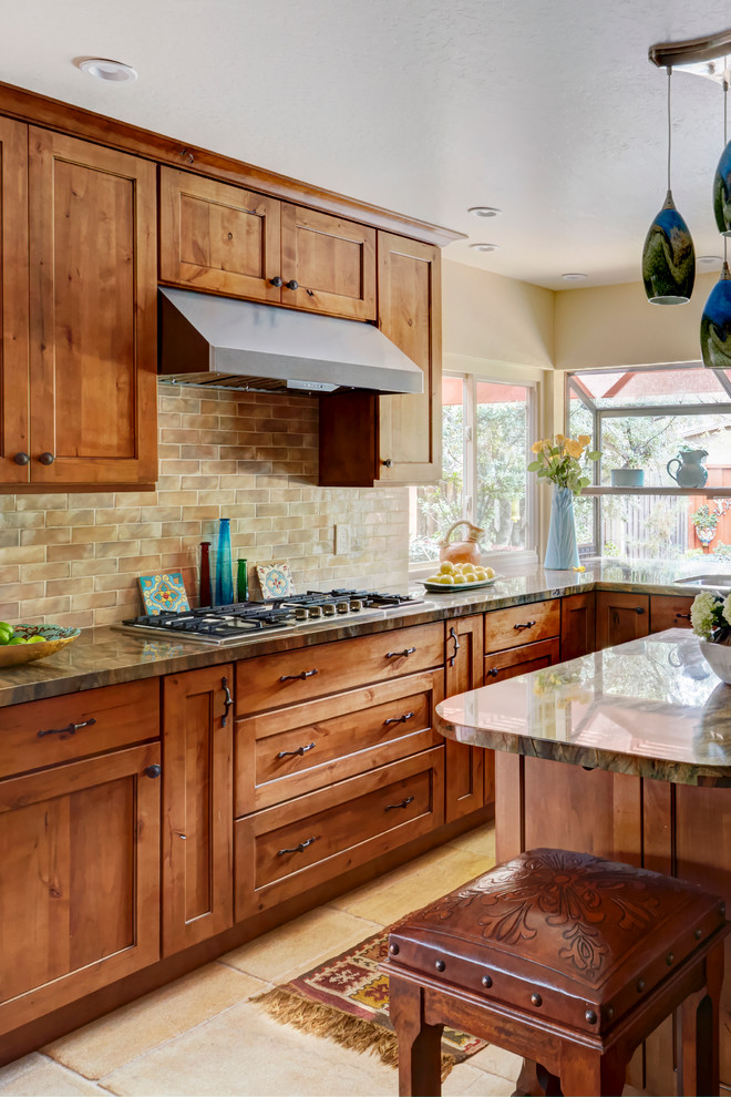 This is an example of a rustic kitchen in San Francisco with medium wood cabinets, granite worktops, beige splashback and stainless steel appliances.