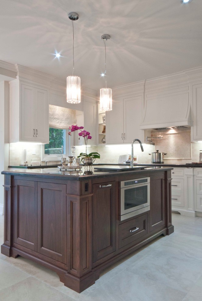 Inspiration for a large timeless u-shaped limestone floor and beige floor open concept kitchen remodel in Toronto with beaded inset cabinets, white cabinets, an island, an undermount sink, granite countertops, beige backsplash, stone tile backsplash and stainless steel appliances