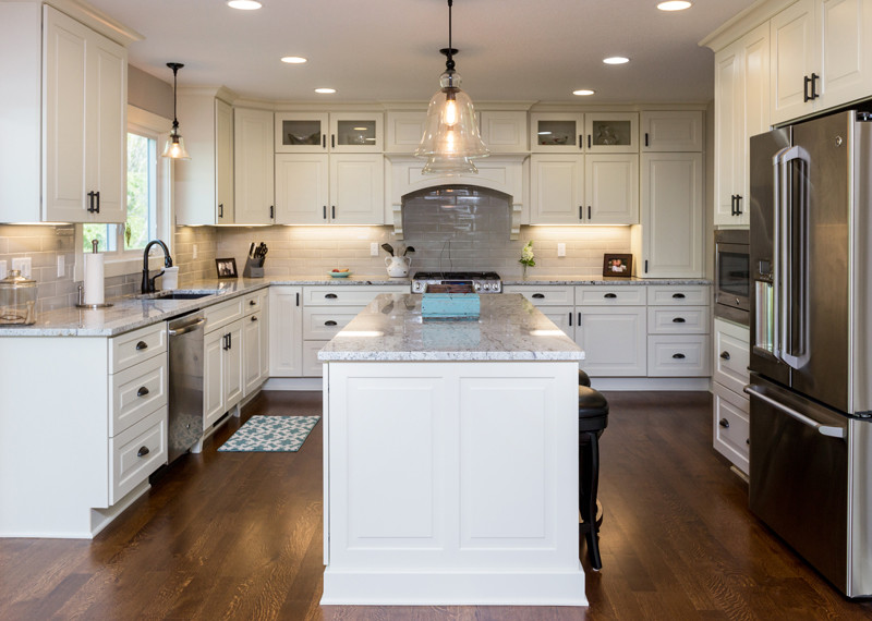 Large transitional u-shaped medium tone wood floor and brown floor eat-in kitchen photo in Other with an undermount sink, raised-panel cabinets, white cabinets, granite countertops, white backsplash, subway tile backsplash, stainless steel appliances, an island and yellow countertops