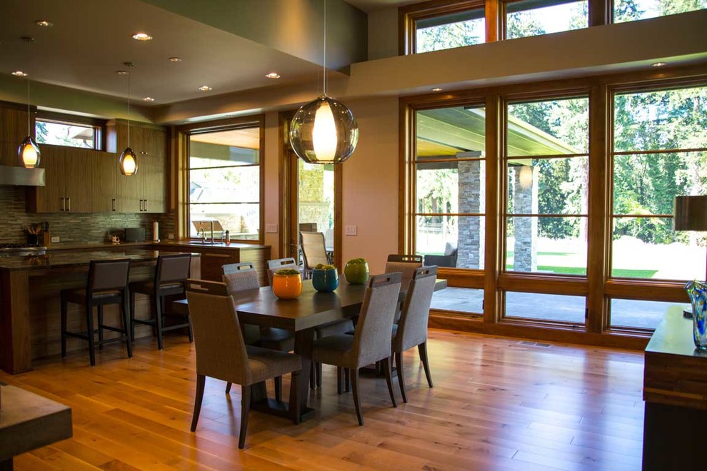 Réalisation d'une grande salle à manger ouverte sur le salon design avec un sol en bois brun.