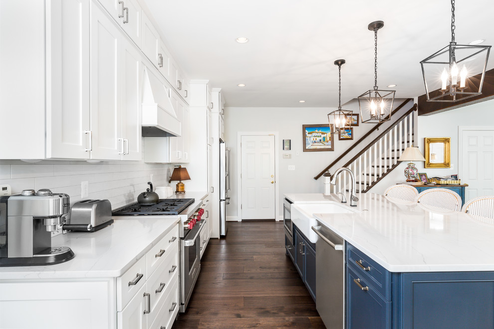 Exempel på ett mellanstort klassiskt vit linjärt vitt kök med öppen planlösning, med en rustik diskho, skåp i shakerstil, vita skåp, vitt stänkskydd, stänkskydd i tunnelbanekakel, rostfria vitvaror, mörkt trägolv, en köksö, brunt golv och bänkskiva i kvartsit