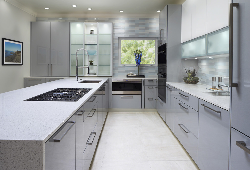 Bild på ett mellanstort funkis l-kök, med en undermonterad diskho, släta luckor, grå skåp, flerfärgad stänkskydd, stänkskydd i glaskakel och en köksö