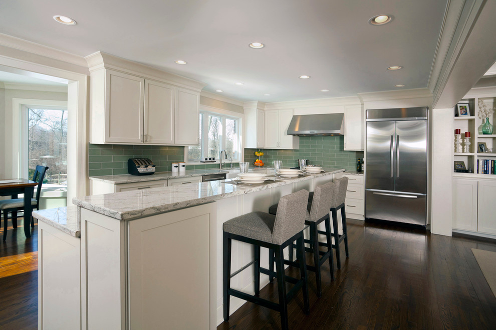 Example of a mid-sized classic dark wood floor kitchen design in Cincinnati with a farmhouse sink, shaker cabinets, white cabinets, granite countertops, green backsplash, glass tile backsplash and stainless steel appliances