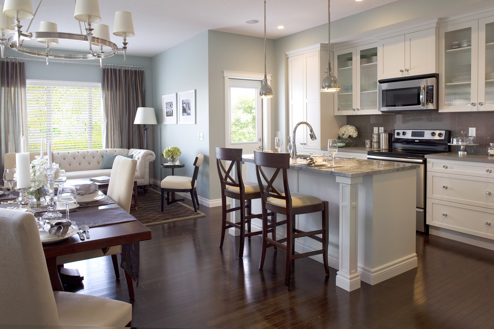 Стильный дизайн: кухня-гостиная в классическом стиле с серым фартуком, фартуком из стекла и белыми фасадами - последний тренд