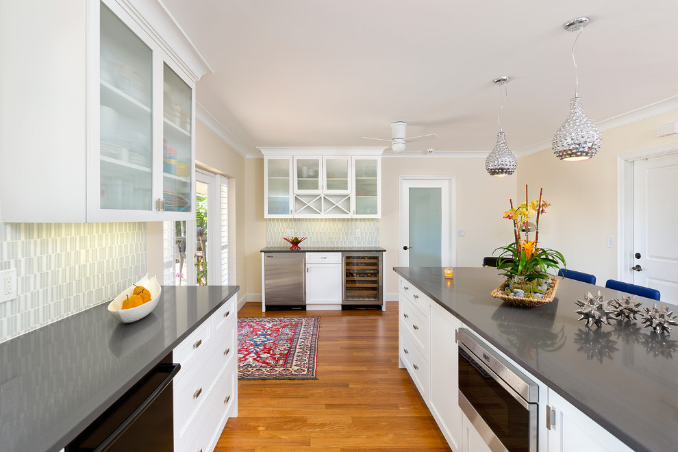 Moderne Küche in L-Form mit Schrankfronten im Shaker-Stil, weißen Schränken, Quarzwerkstein-Arbeitsplatte, Rückwand aus Glasfliesen, braunem Holzboden und Kücheninsel in Miami
