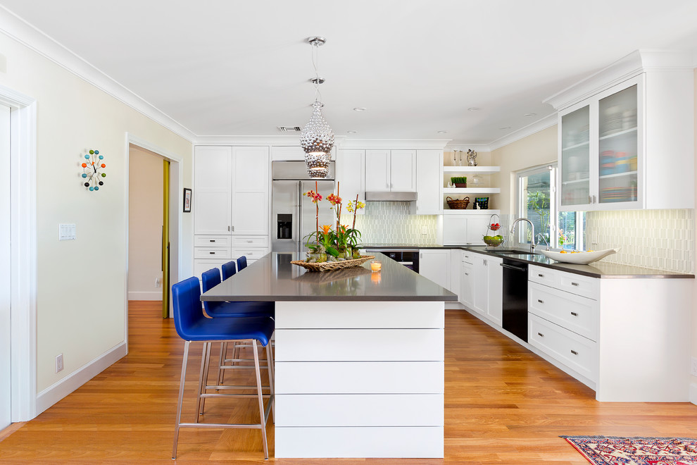 マイアミにある高級なコンテンポラリースタイルのおしゃれなキッチン (シェーカースタイル扉のキャビネット、白いキャビネット、クオーツストーンカウンター、ガラスタイルのキッチンパネル、無垢フローリング) の写真