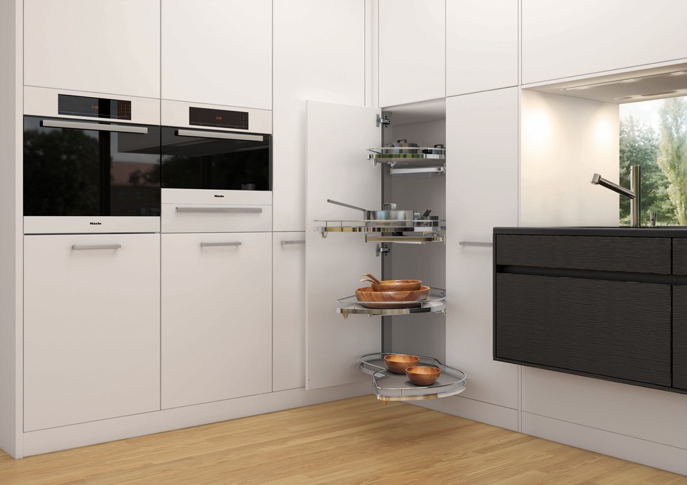 Immagine di una cucina design di medie dimensioni con ante lisce, ante bianche, top in superficie solida, elettrodomestici in acciaio inossidabile e parquet chiaro