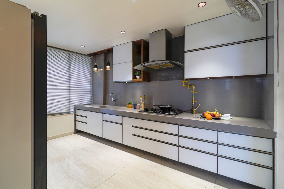 Medium sized contemporary galley kitchen in Ahmedabad with an integrated sink, flat-panel cabinets, grey cabinets, grey splashback, integrated appliances, no island, beige floors and grey worktops.