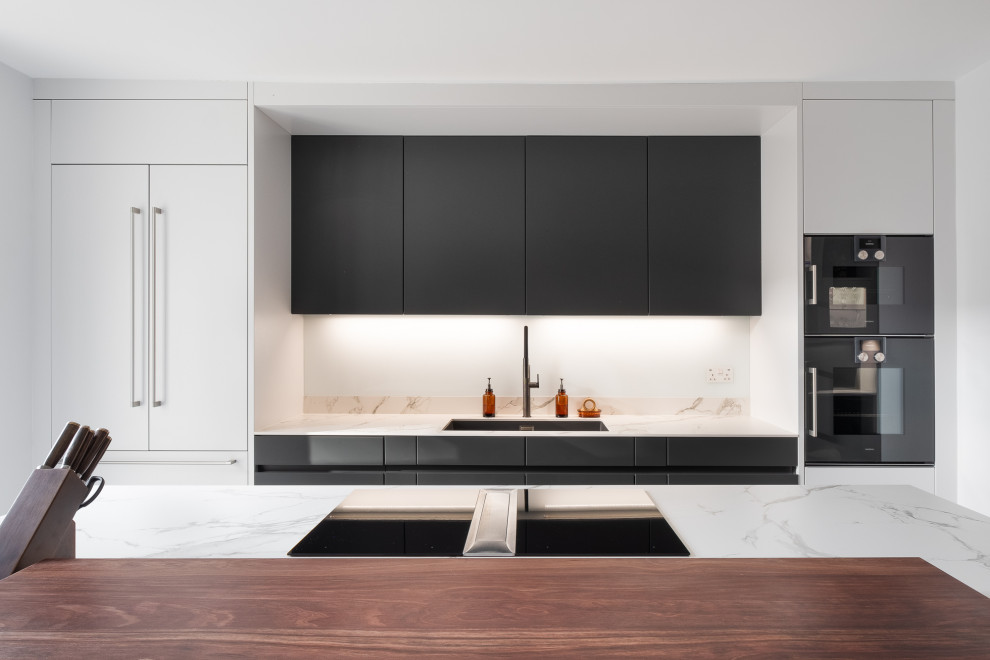 Ispirazione per una cucina moderna di medie dimensioni con ante lisce, ante grigie, top in superficie solida, elettrodomestici neri, pavimento in marmo e top bianco