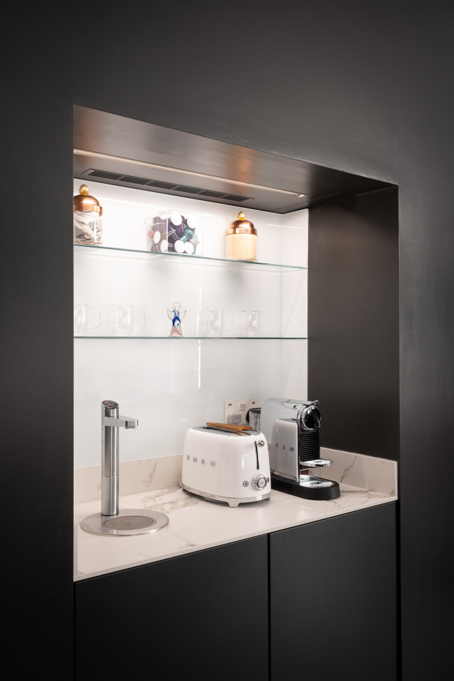 Idee per una cucina moderna di medie dimensioni con ante lisce, ante grigie, top in superficie solida, elettrodomestici neri, pavimento in marmo e top bianco