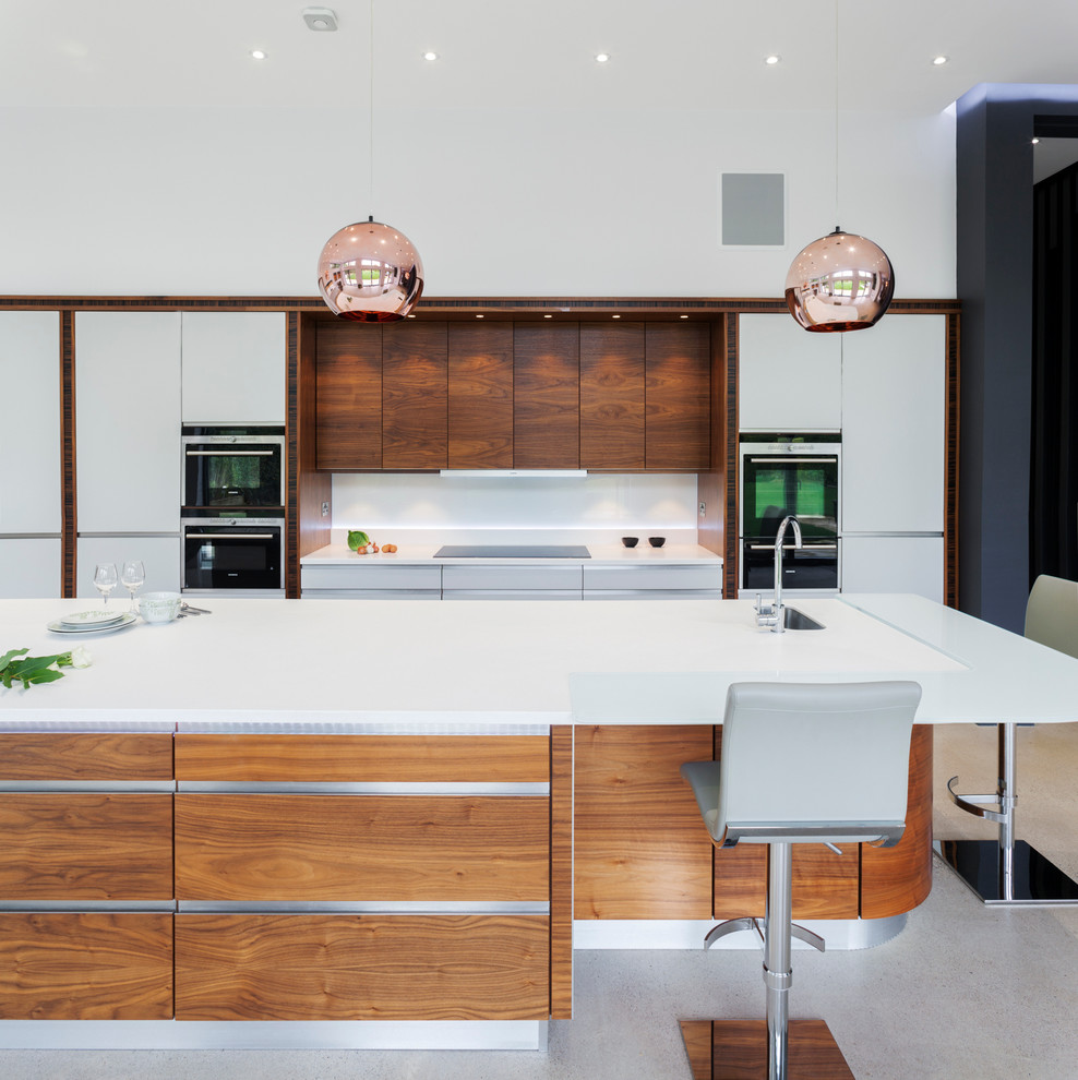 This is an example of a medium sized contemporary galley open plan kitchen in Other with white cabinets, white splashback, an island, flat-panel cabinets, wood worktops, ceramic splashback, stainless steel appliances, concrete flooring and a submerged sink.